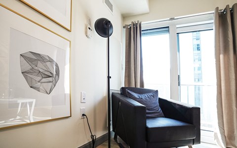 a living room with a black leather chair and a black floor lamp